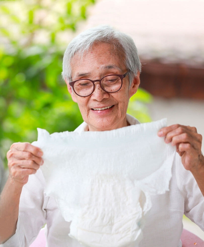 An Old man holding a non-woven diaper with smiling