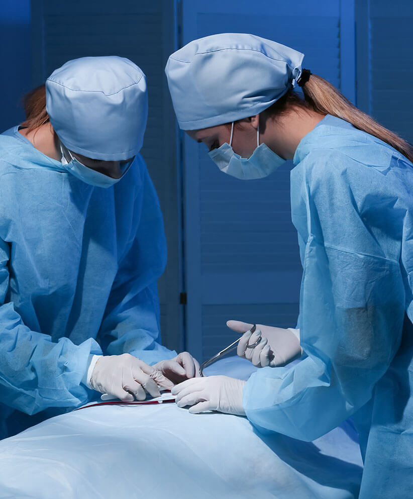 Lady Doctors are wearing a blue non-woven surgical gown, cap, and mask in surgical ward