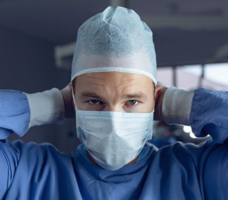 A doctor is wearing blue non woven medical products such as non-woven gown, cap and mask